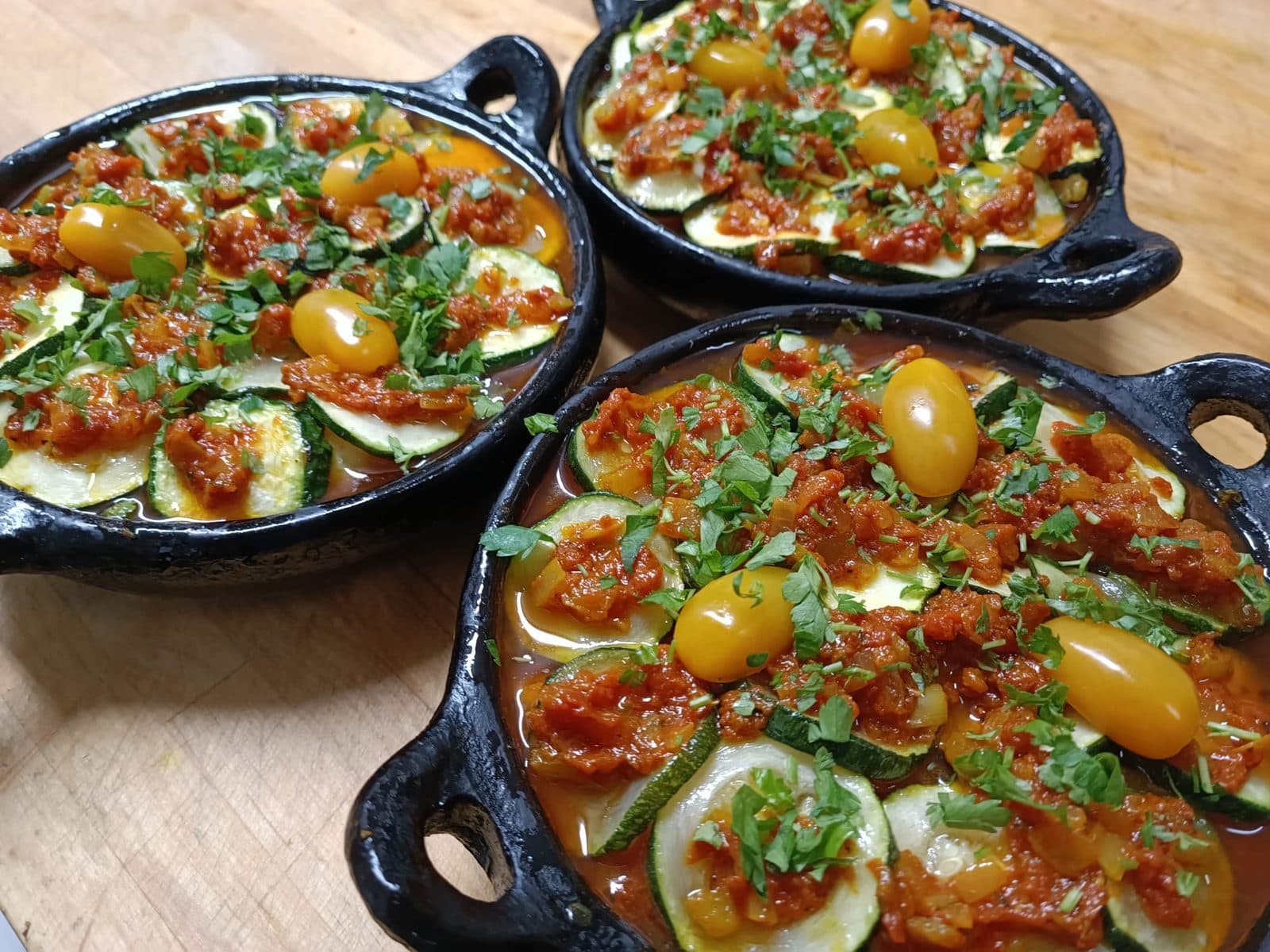 Voorgerecht met courgette en tomaat in aardewerken schaaltjes